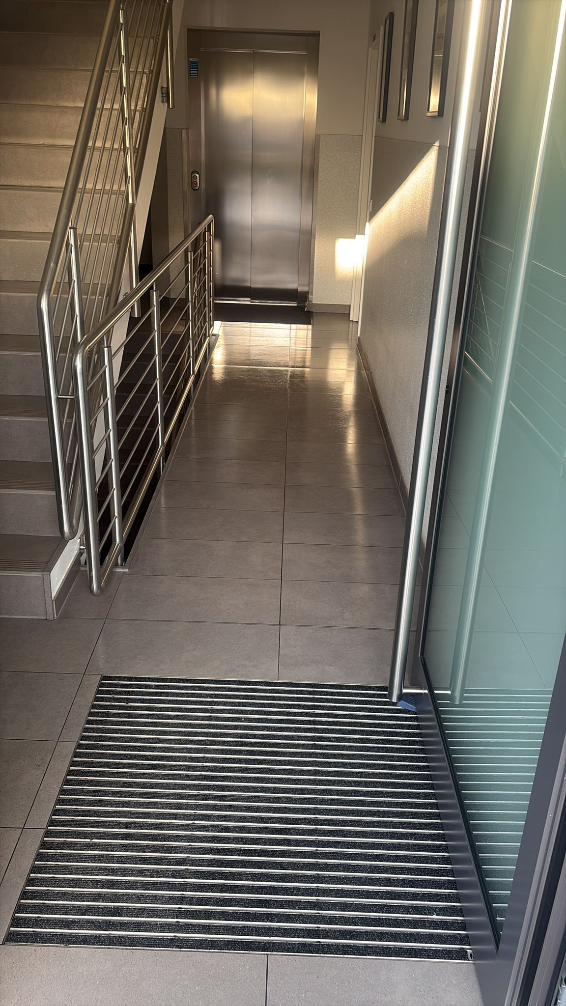 Gereinigtes Treppenhaus mit Eingangsbereich und Aufzug